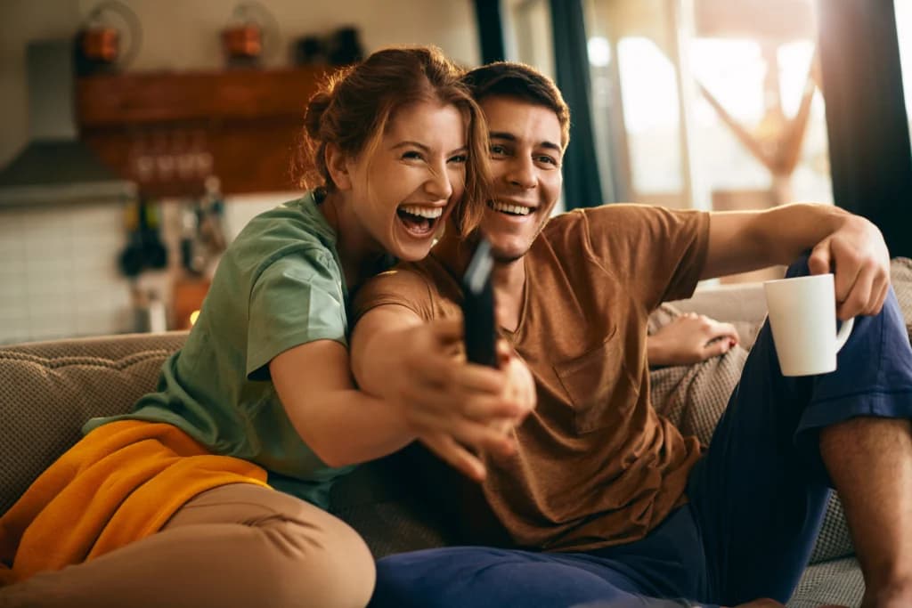 Couple regardant la télévision avec une télécommande