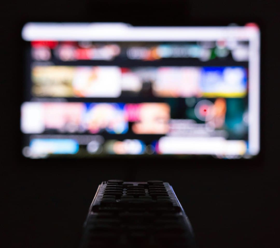 Télécommande posée devant un téléviseur allumé, prêt pour IBO Player